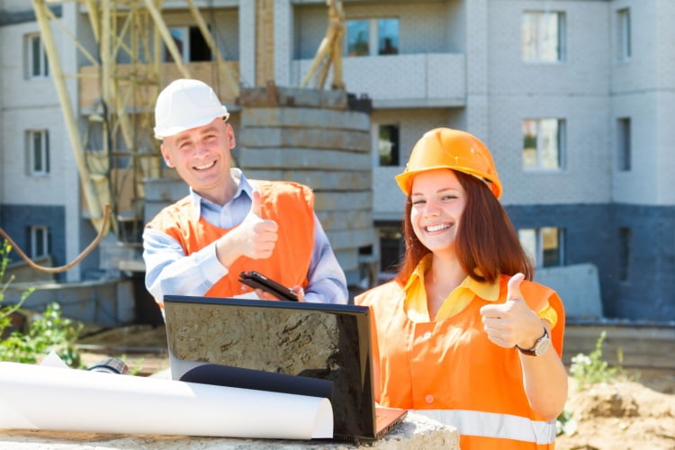 Two happy construction crew members at work